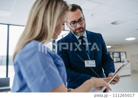 Pharmaceutical sales representative talking with doctor, presenting new medication. Nurse talking with hospital director, manager about contract, documentation. Medical, healthcare unions. 111265017