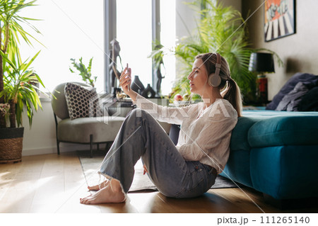 Female nurse or doctor enjoying free time at home after work, listening meditation relaxing music. Work-life balance for healthcare worker. Female nurse or doctor enjoying free time at home after work, listening meditation relaxing music. Work-life balance for healthcare worker. 111265140