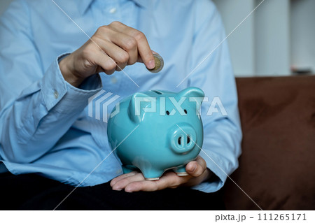 woman hand putting gold coin into pink piggy bank and use laptop for online marketing, step up start up business to suscess, Saving money for future plan and retirement fund concept woman hand putting gold coin into pink piggy bank and use laptop for online marketing, step up start up business to suscess, Saving money for future plan and retirement fund concept 111265171