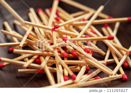 Matchsticks pile with red sulfur in household wooden bowl close up. 111265827