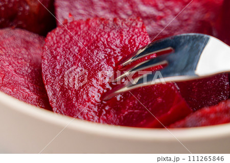 Eating fresh boiled red beets with a fork. Macro shot. Healthy eating concept Eating fresh boiled red beets with a fork. Macro shot. Healthy eating concept 111265846