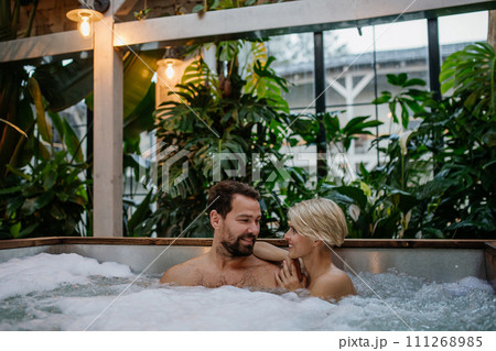Beautiful mature couple relaxing in hot tub, enjoying romantic wellness weekend in spa. Concept of Valentine's Day. 111268985