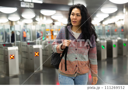 Asian woman passing through ticket gates in public transportation station Asian woman passing through ticket gates in public transportation station 111269552