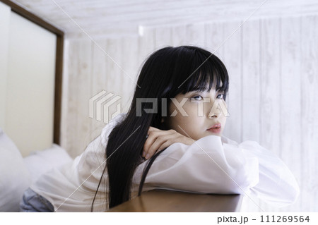 部屋のロフトでくつろぐ若い女性 111269564