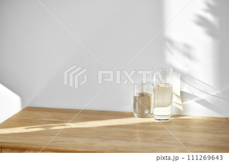 A water cup and shadow on a table in the sunlight. A water cup and shadow on a table in the sunlight. 111269643