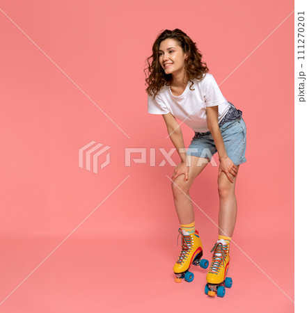 A young lady with rainbow quad rollers on pink background copyspace A young lady with rainbow quad rollers on pink background copyspace 111270201
