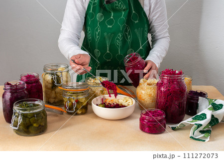 Woman fermenting fresh vegetables Woman fermenting fresh vegetables 111272073