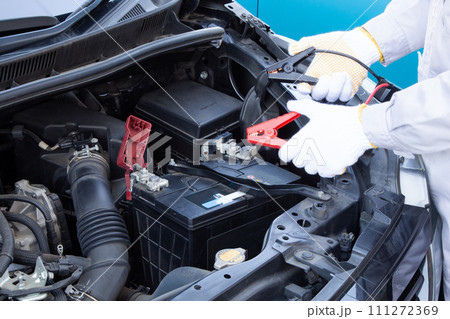 車のバッテリーのトラブル（ワニ口クリップを持つ整備士） 111272369