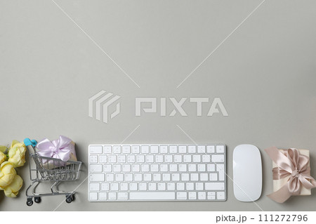 Keyboard and flowers with a shopping cart, on a light background. 111272796