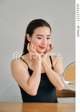 顔をマッサージして肌のお手入れをする30代女性 顔をマッサージして肌のお手入れをする30代女性 111273350