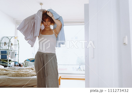 Teenager girl looking at clothes in wardrobe Teenager girl looking at clothes in wardrobe 111273432