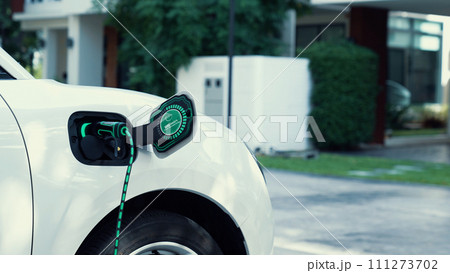 Electric car plugged in with home charging station. Peruse 111273702