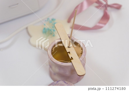 The process of making a massage candle using ingredients oils and wax measure weigh stir add close-up of women's hands. food thermometer measure wax temperature women's party women witches witchcraft The process of making a massage candle using ingredients oils and wax measure weigh stir add close-up of women's hands. food thermometer measure wax temperature women's party women witches witchcraft 111274180