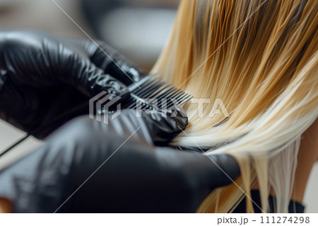 Hair master dyies dark hair to blond in a hair salon Hair master dyies dark hair to blond in a hair salon 111274298