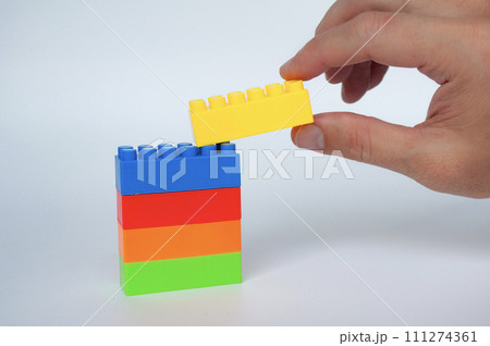 Plastic building-block toys on white cover background. Childhood toy concept Plastic building-block toys on white cover background. Childhood toy concept 111274361