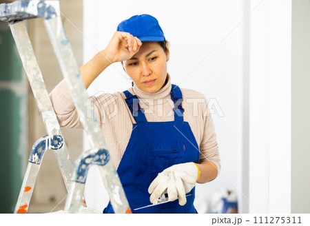 Portrait of frustrated woman builder standing in apartment Portrait of frustrated woman builder standing in apartment 111275311