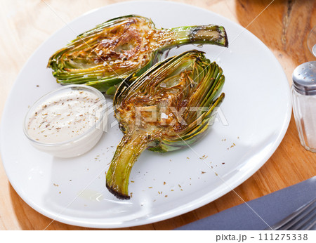 Roasted halves of artichokes 111275338