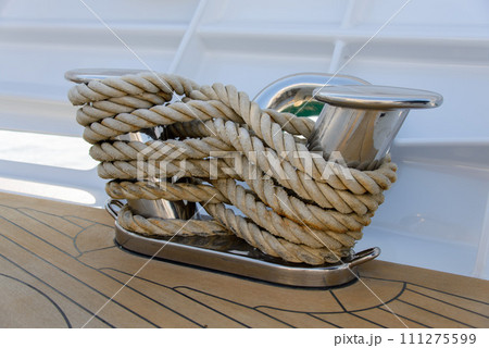 Stainless steel cleat on a superyacht. Mooring arrangements. Rollers. Marine hardware. Mooring. 111275599