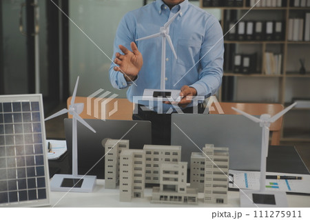 Close-up at tablet, Engineers pointing at tablet with their hands. To jointly design the use of renewable energy with wind and solar energy. Concept of using renewable energy. Close-up at tablet, Engineers pointing at tablet with their hands. To jointly design the use of renewable energy with wind and solar energy. Concept of using renewable energy. 111275911