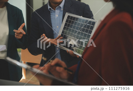 Close-up at tablet, Engineers pointing at tablet with their hands. To jointly design the use of renewable energy with wind and solar energy. Concept of using renewable energy. 111275916