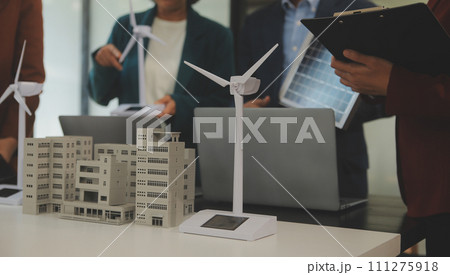 Close-up at tablet, Engineers pointing at tablet with their hands. To jointly design the use of renewable energy with wind and solar energy. Concept of using renewable energy. 111275918