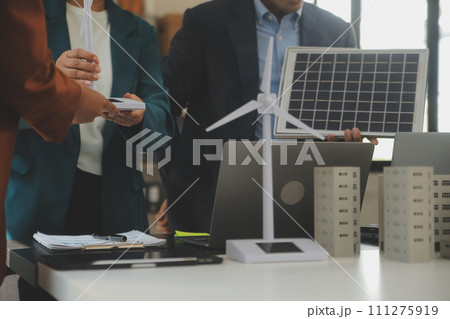 Close-up at tablet, Engineers pointing at tablet with their hands. To jointly design the use of renewable energy with wind and solar energy. Concept of using renewable energy. 111275919