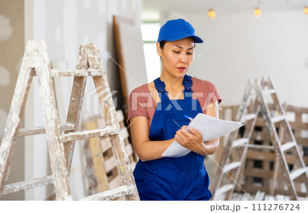 Female engineer matching check list during repair works 111276724
