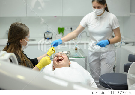 Doctor woman dentist treats the patient's teeth, proper dental care. Dental care and hygiene concept. Selective focus. Doctor woman dentist treats the patient's teeth, proper dental care. Dental care and hygiene concept. Selective focus. 111277216