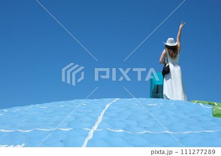 View from the back of a little baby girl waving through an airport terminal window to a taking off jet. Daughter saying goodbye to the departing plane. High quality 4k footage 111277289