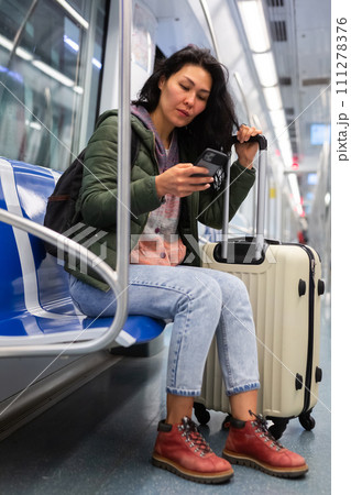 Woman passenger using phone in subway car 111278376