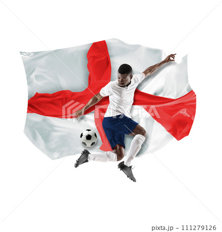 Concentrated African man, soccer player in uniform playing, hitting ball against white background with flag of England 111279126
