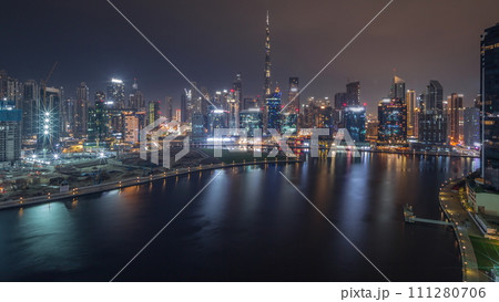 Aerial view to Dubai Business Bay and Downtown with the various skyscrapers and towers all night timelapse 111280706