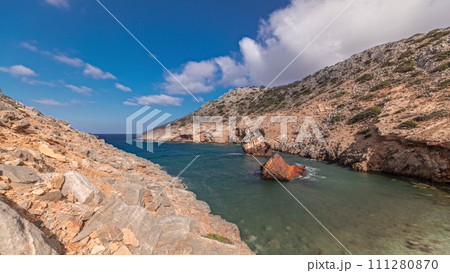 An abandoned rusty ship in the sea timelapse near huge rock formations in Navagio Beach, Amorgos Island, Greece 111280870