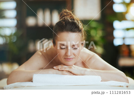 relaxed modern woman in spa salon laying on massage table relaxed modern woman in spa salon laying on massage table 111281653