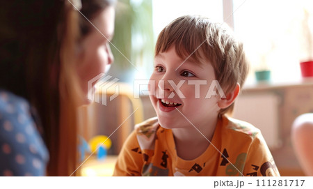 A cheerful laughing deaf-mute boy looks at the teacher, lip-reading. Generated AI 111281717
