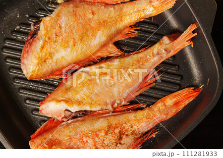 Fresh sea bass sizzles to perfection in a hot skillet, showcasing a delightful evening feast in the making. 111281933