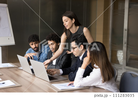 Confident busy coach woman training diverse team of new employees Confident busy coach woman training diverse team of new employees 111283035