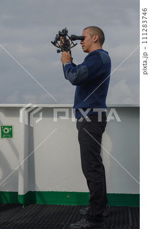 Seaman with sextant on navigational bridge 111283746