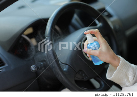 Hand of woman is spraying alcohol,disinfectant spray in car,safety,prevent infection of Covid 19 virus,coronavirus, contamination of germs or bacteria.Alcohol Sanitizer,Hygiene concept. 111283761