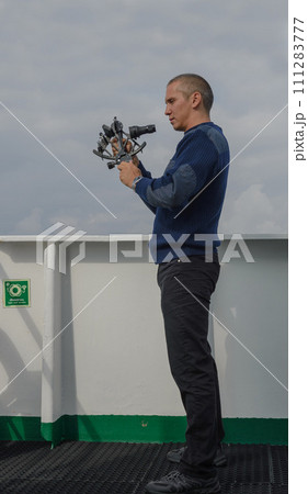Seaman with sextant on navigational bridge Seaman with sextant on navigational bridge 111283777