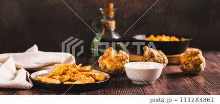 Pieces of celery root fried with paprika on a plate on the table web banner 111283861