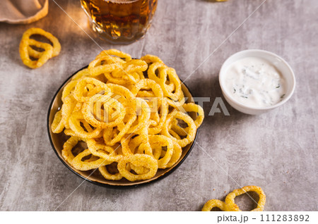 Homemade fried onion rings on a plate and sauce on the table 111283892