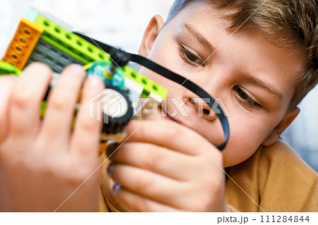 Smart child science class robotics kids technology child constructor robotics learning technology toy. Little boy makes robot toy car. Kids stem education. Smart boy assemble constructor kids workshop 111284844