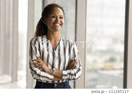 Happy African professional woman in casual shirt posing in office 111285117