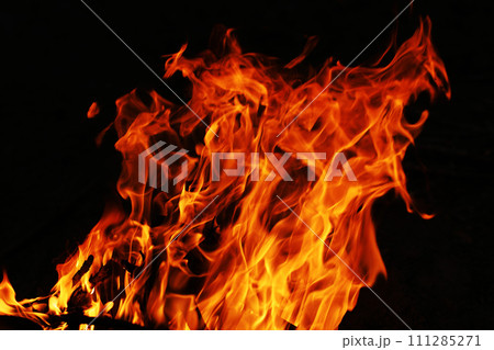 Fire creates infinity shapes when it burns. The orange from the flame and the black backgroud creates interesting textures. Flames from hell. Burning power. 111285271