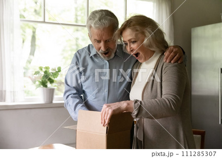 Excited senior couple unboxing postal delivery receive great gift surprise Excited senior couple unboxing postal delivery receive great gift surprise 111285307