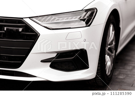 The headlamp of the new clean white sports car is of aggressive form with a part of the bonnet and black wheel, bumper 111285390