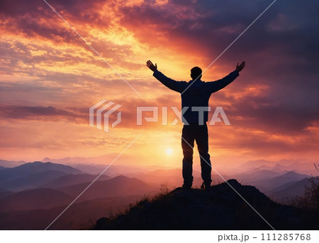 Silhouette of a man standing on top of a mountain with his hands up at sunset Silhouette of a man standing on top of a mountain with his hands up at sunset 111285768