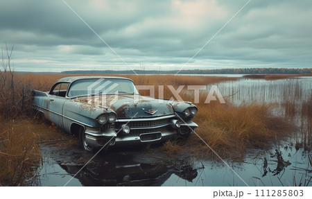 abandoned old grey car partially submerged in water, cloudy sky abandoned old grey car partially submerged in water, cloudy sky 111285803