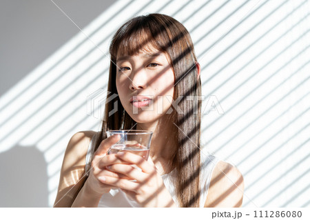 コップを持つ若い女性 111286080